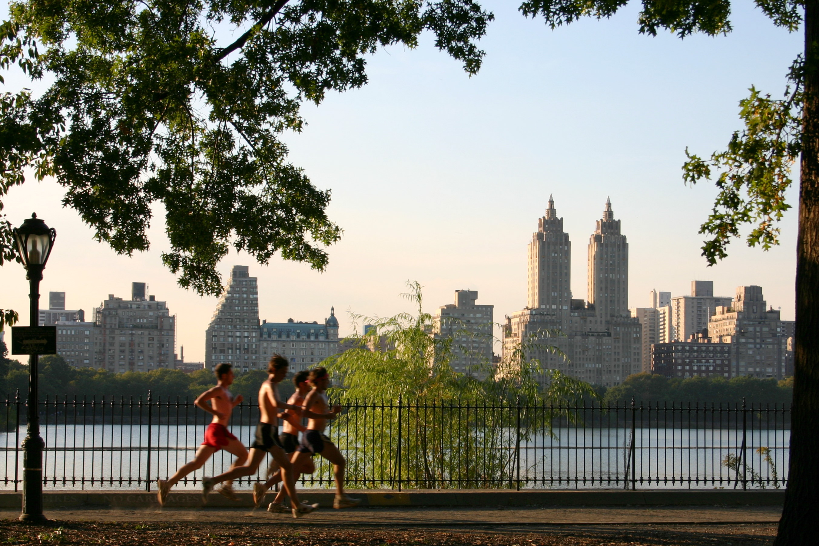 Real runners on the Central Park reservoir pedestrian path with the New York skyline behind them